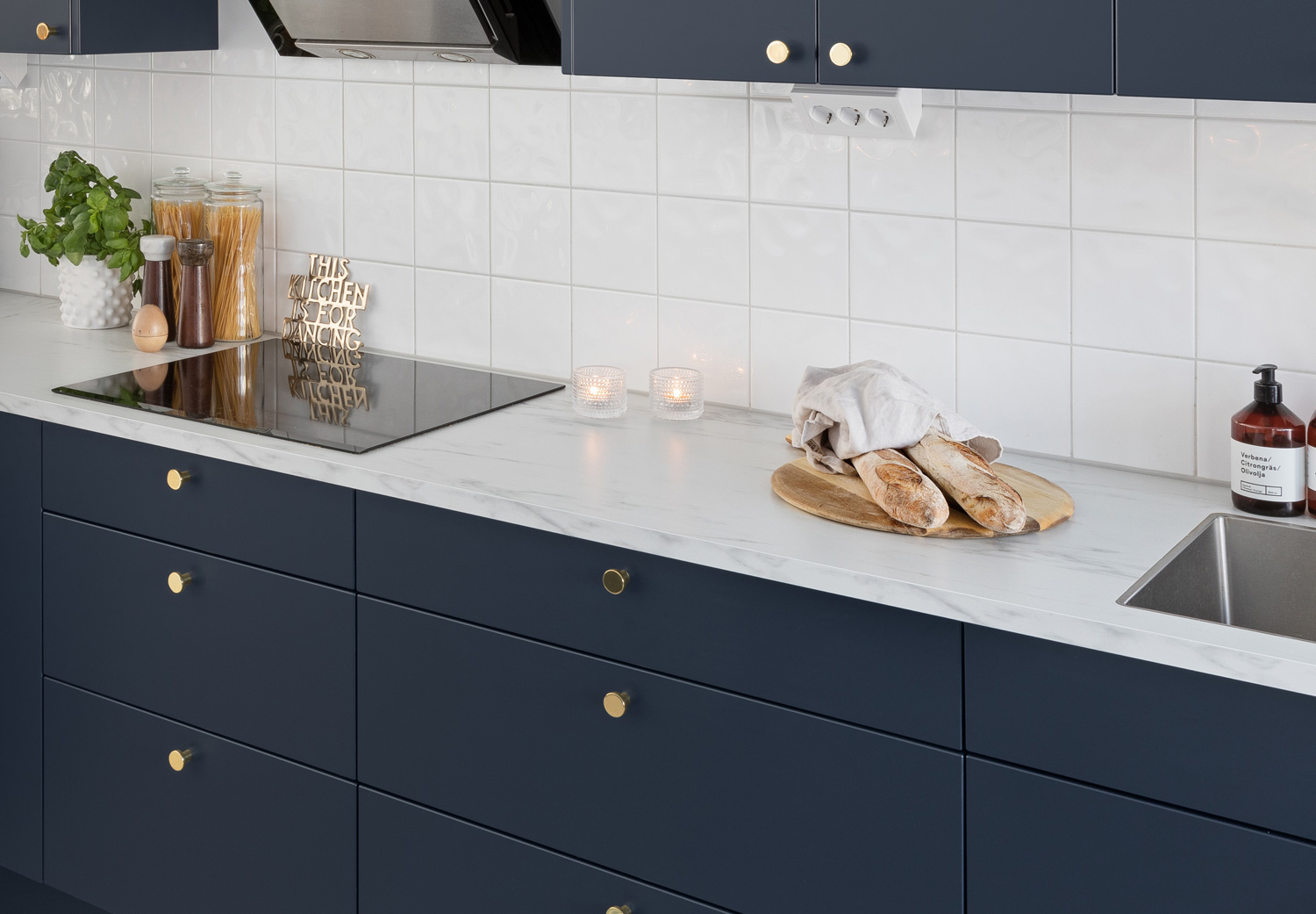 Image 08 Kjøkken med lys benk med marmor-mønster og fronter i den mørke blåfargen storm